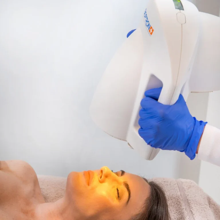 Gesichtsbehandlung mit einer Bioptron-Lampe bei liegender Frau