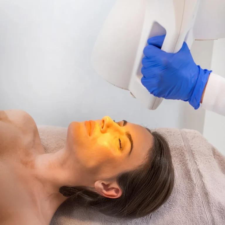 Gesichtsbehandlung mit einer Bioptron-Lampe bei liegender Frau