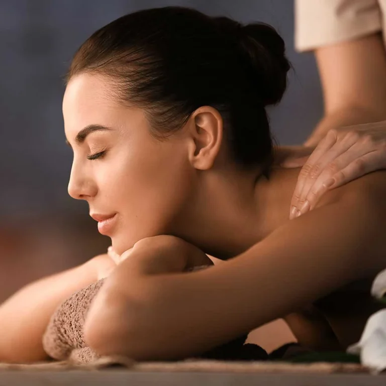 Frau liegt entspannt während einer Massagebehandlung