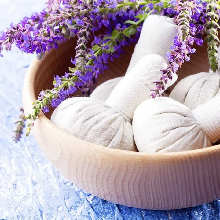 Kräuterstempel mit Lavendel in einer Holzschale