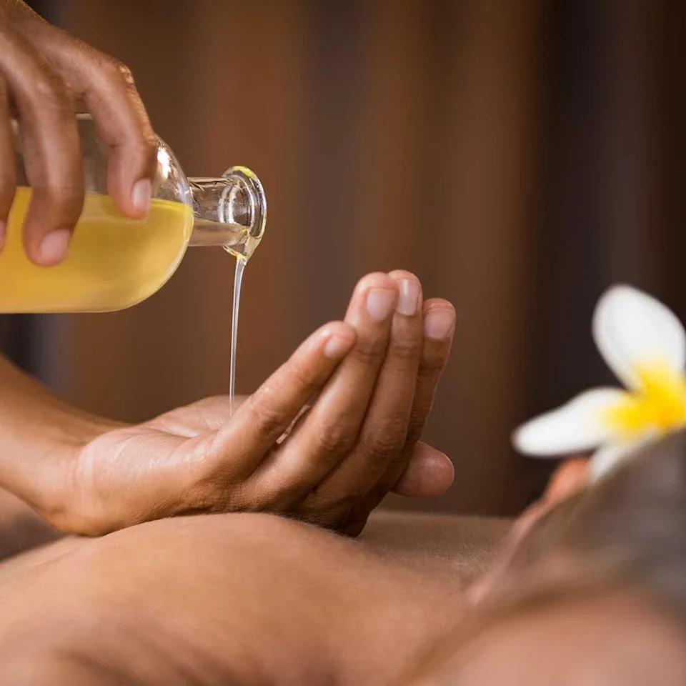 Vorbereitung mit Öl, das aus einer Glasflasche in die Hand gegossen wird