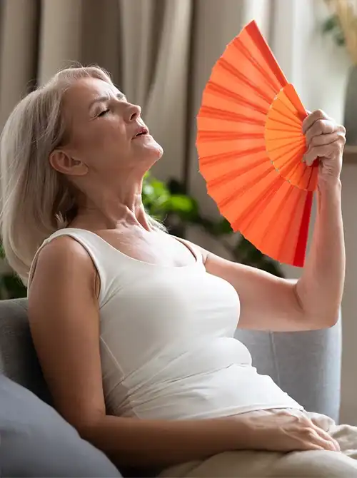 Frau sitzt entspannt und fächelt sich Luft zu